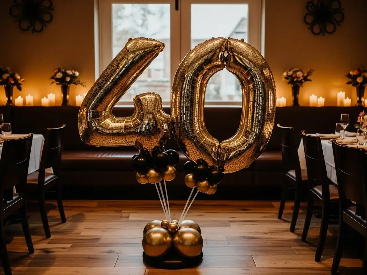 Número 40 gigante con globos dorados en cumpleaños de adulto en un restaurante